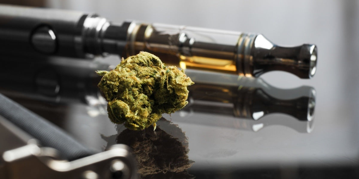 Cogollos de cannabis junto a cartuchos de vape y accesorios