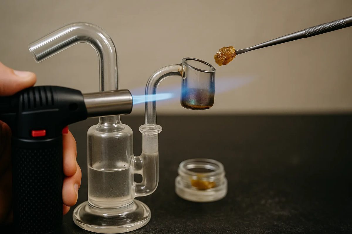 A person using a dab rig to inhale cannabis concentrate, close-up view in a relaxed home setting.